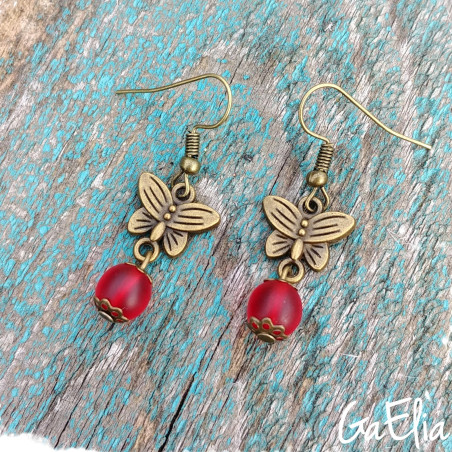 Boucles d'oreilles papillons avec perle en verre rouge.