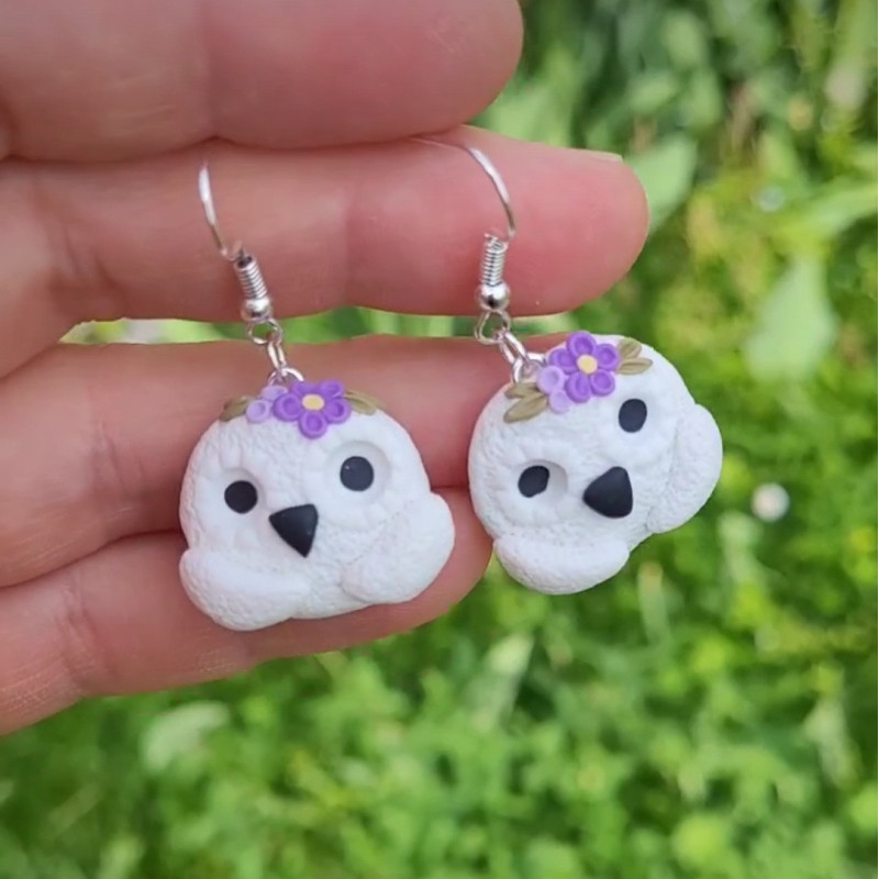 Boucles d’oreille bohème avec petite fleur mauve représentent un chouette blanche.