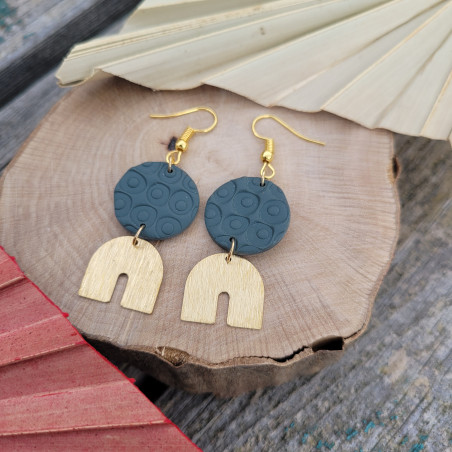 Boucles d’oreilles bleu foncé et doré avec motifs ronds.