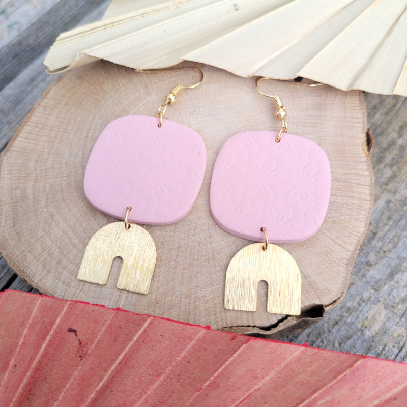 Boucles d’oreilles rose pastel et doré avec formes carrées.