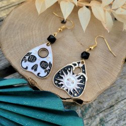 Boucles d'oreilles planchette divinatoire avec motifs soleil, lune et perles de cristal noir, design ésotérique en métal doré.